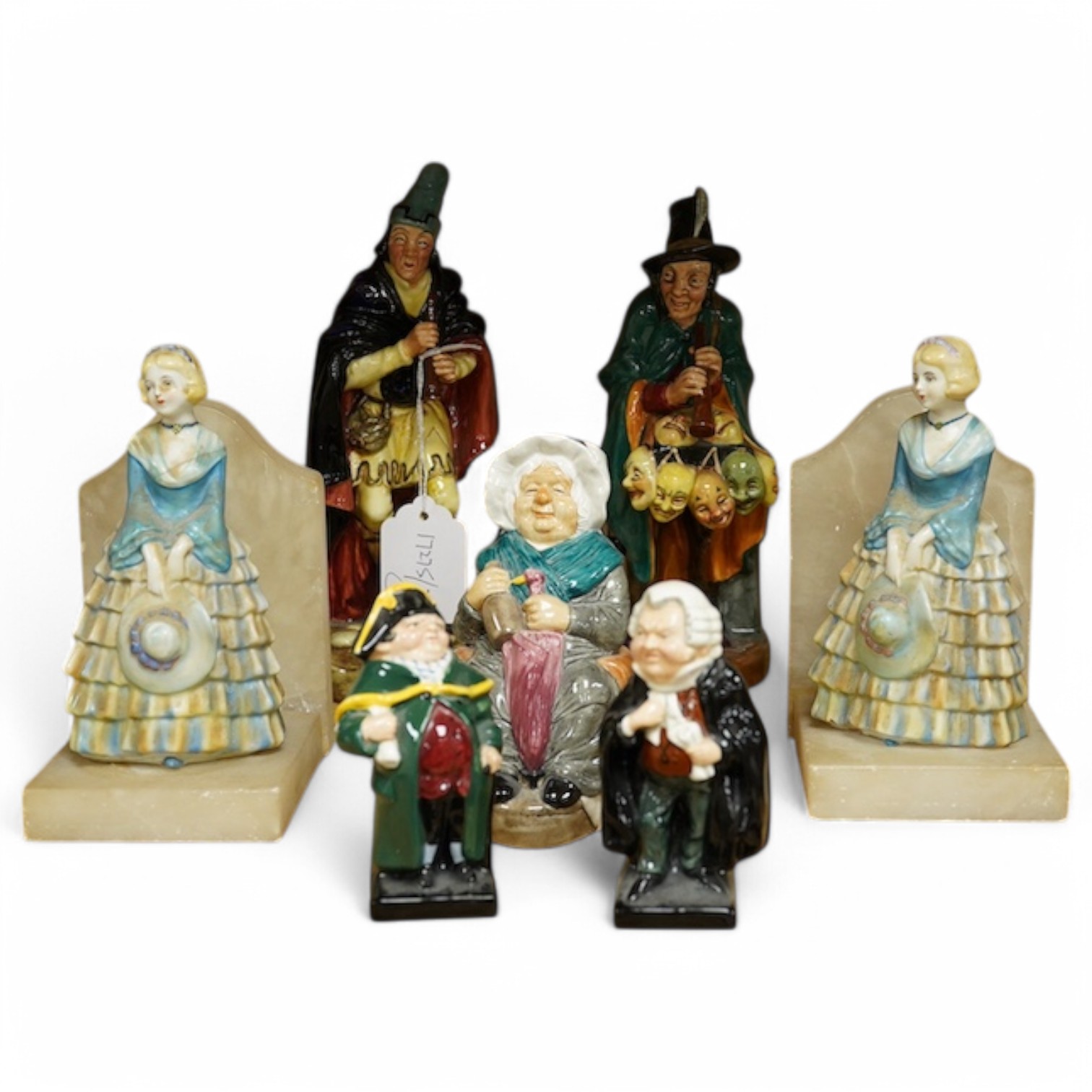 Two Royal Doulton figures comprising; The Mask Seller and Pied Piper together with three other figures and a pair of alabaster bookends, largest 24cm high. Condition - mostly fair/good